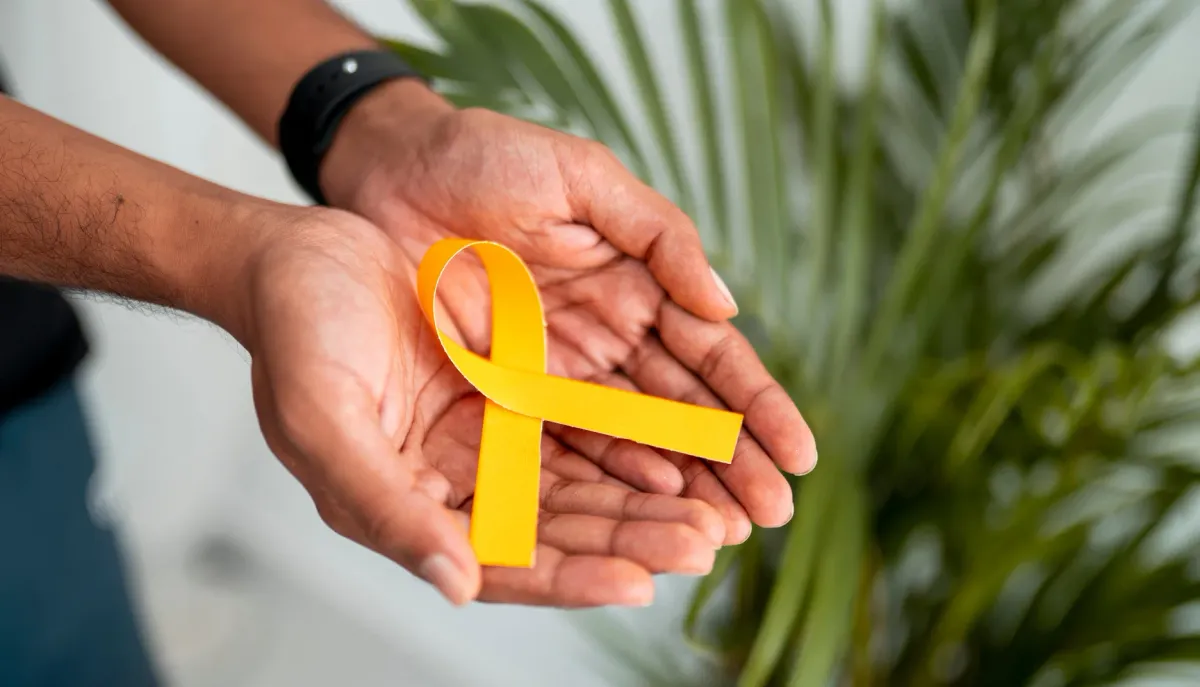 Deux mains ouvertes tenant un ruban jaune, symbole de l'endométriose