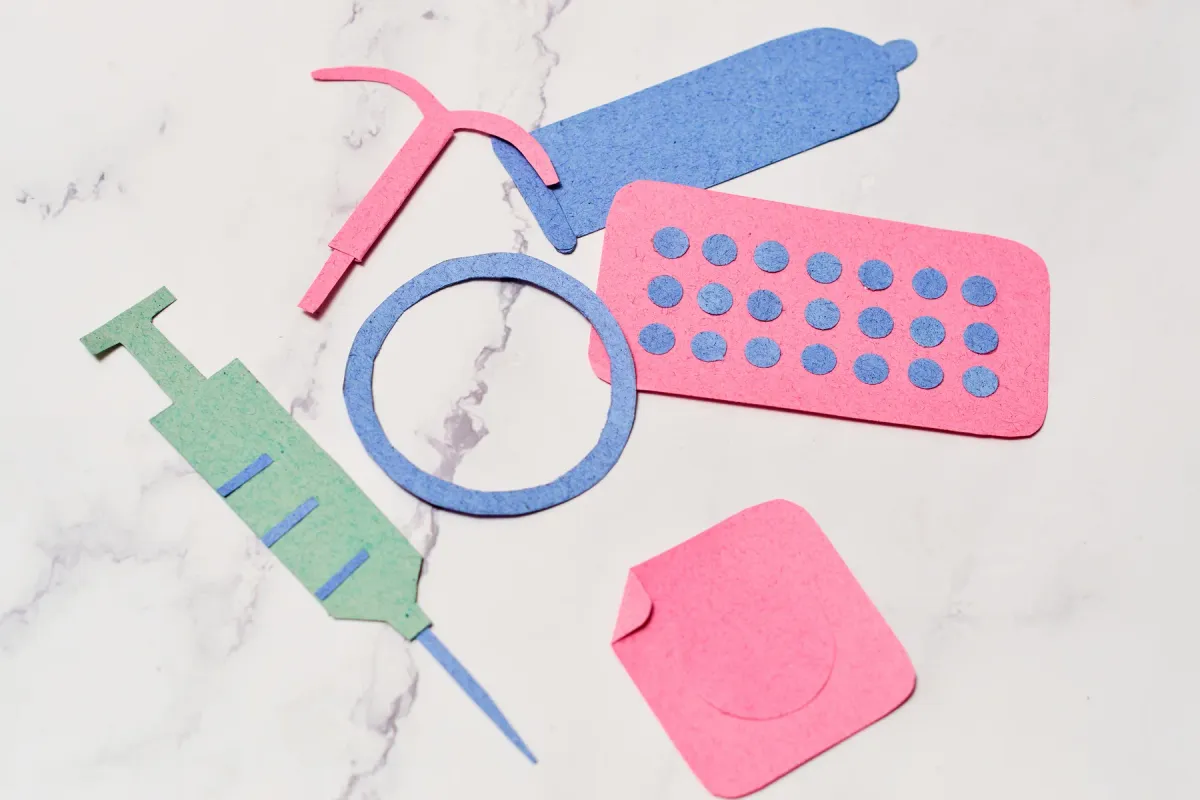 Illustration en papier découpé des différents moyens de contraception : pilule, stérilet, anneau, patch, implant