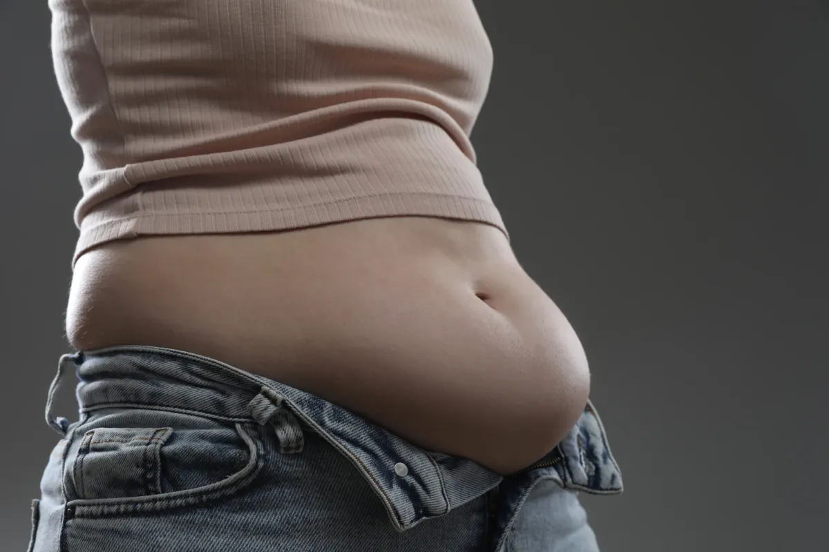 Profil du ventre gonflé d'une femme, les mains posées autour
