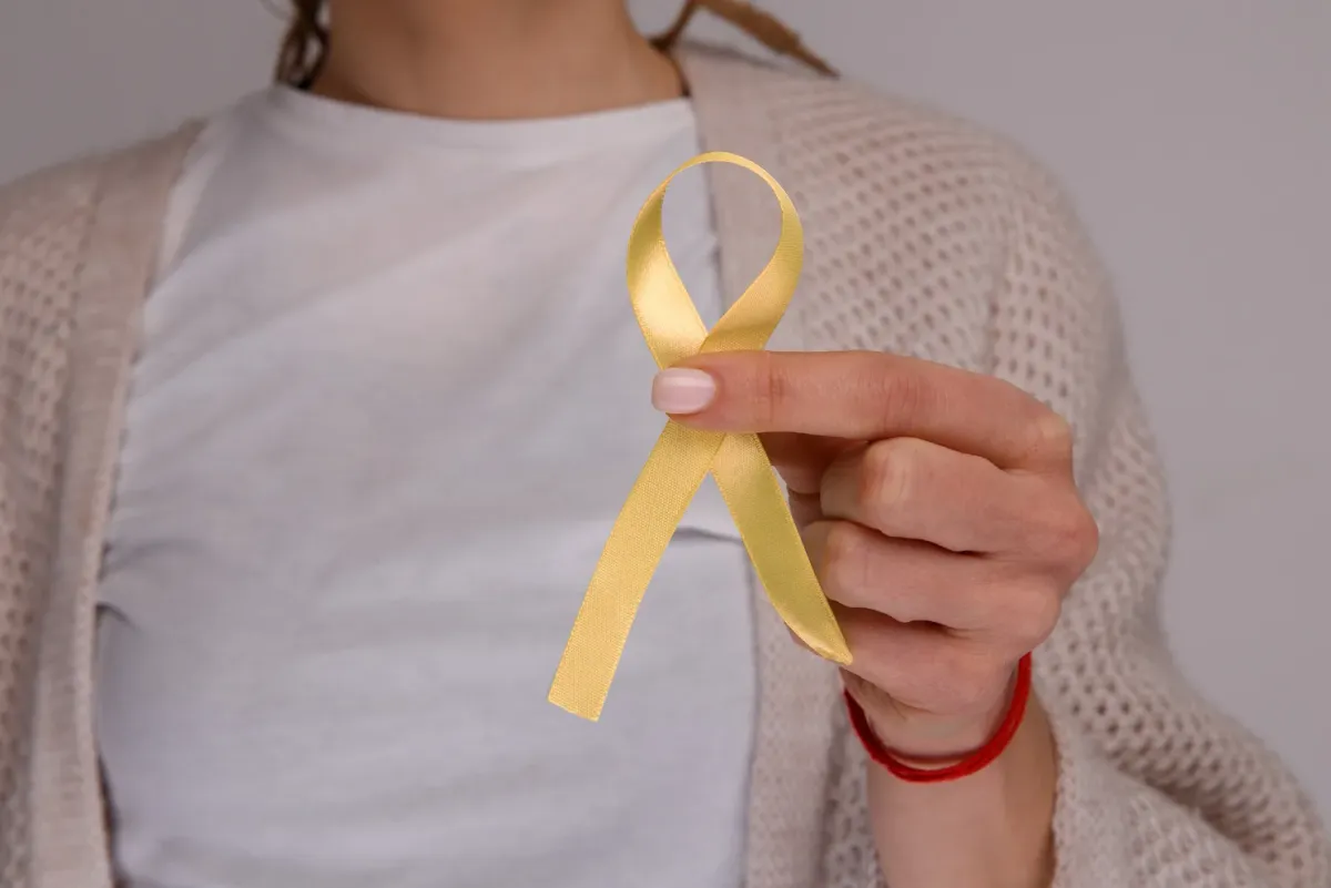 Femme tenant un ruban jaune, symbole de sensibilisation à l'endométriose