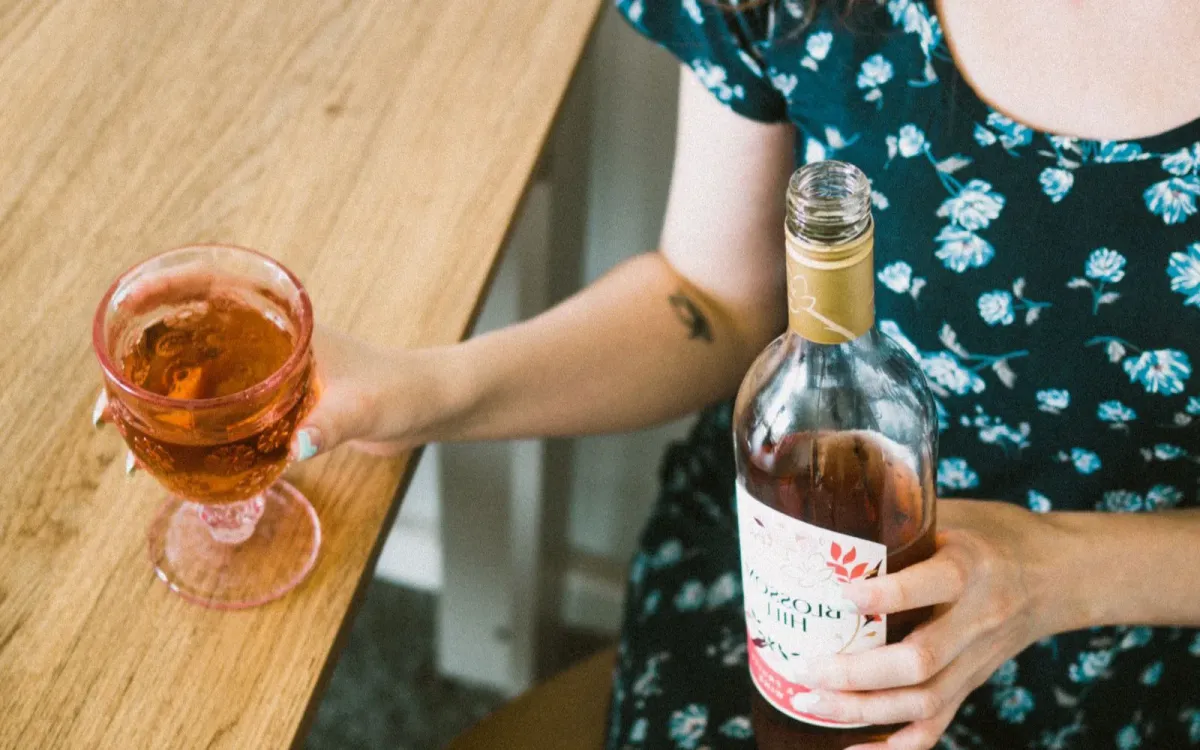 Femme qui se sert un verre de vin en fin de journée
