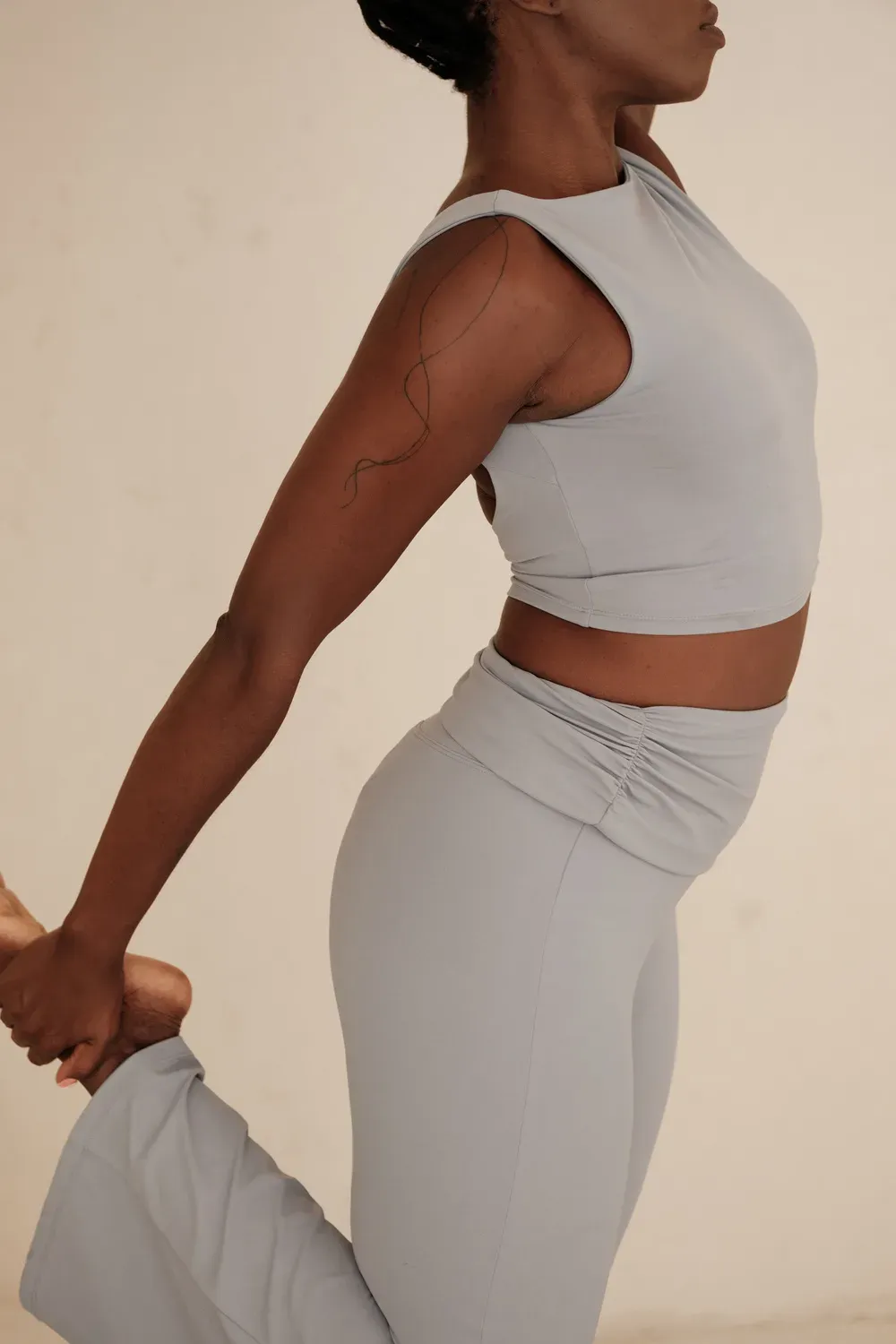 Femme en tenue de sport réalisant un étirement, en lien avec l'absence de règles liée au sport intensif