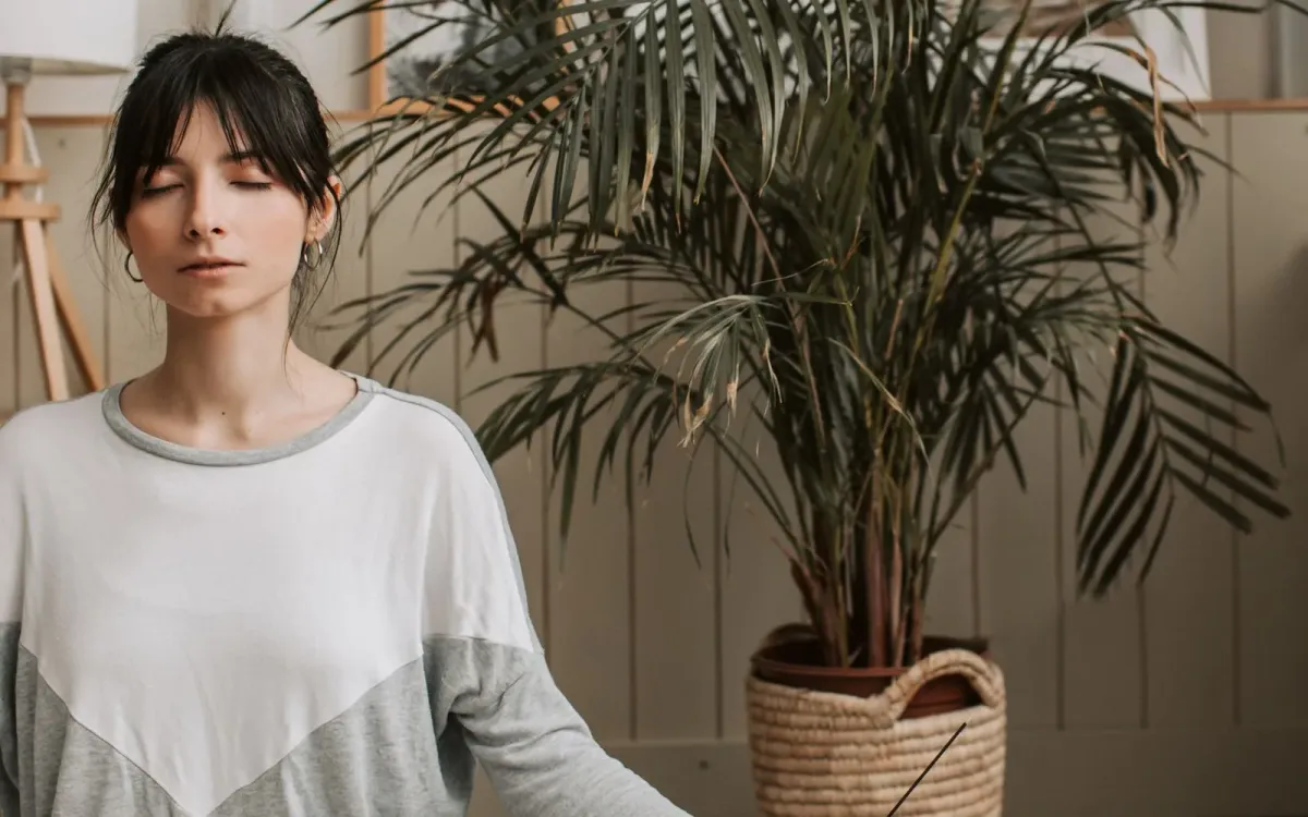 Femme en méditation, un bâton d'encens allumé à côté d'elle