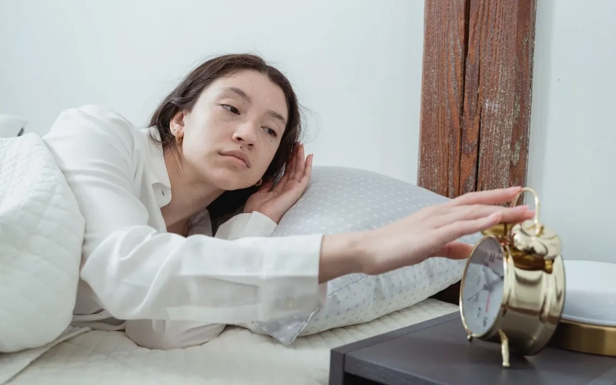 Femme qui éteint son réveil au petit matin
