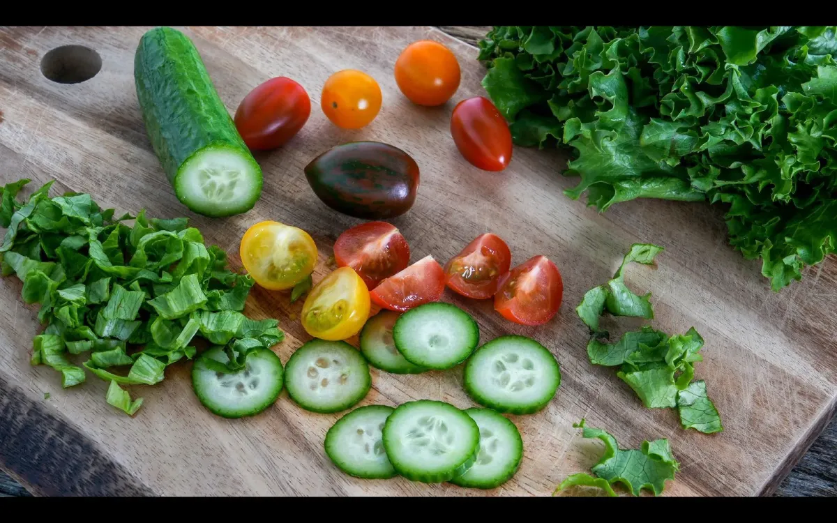 Concombre, tomates et laitue sur une planche