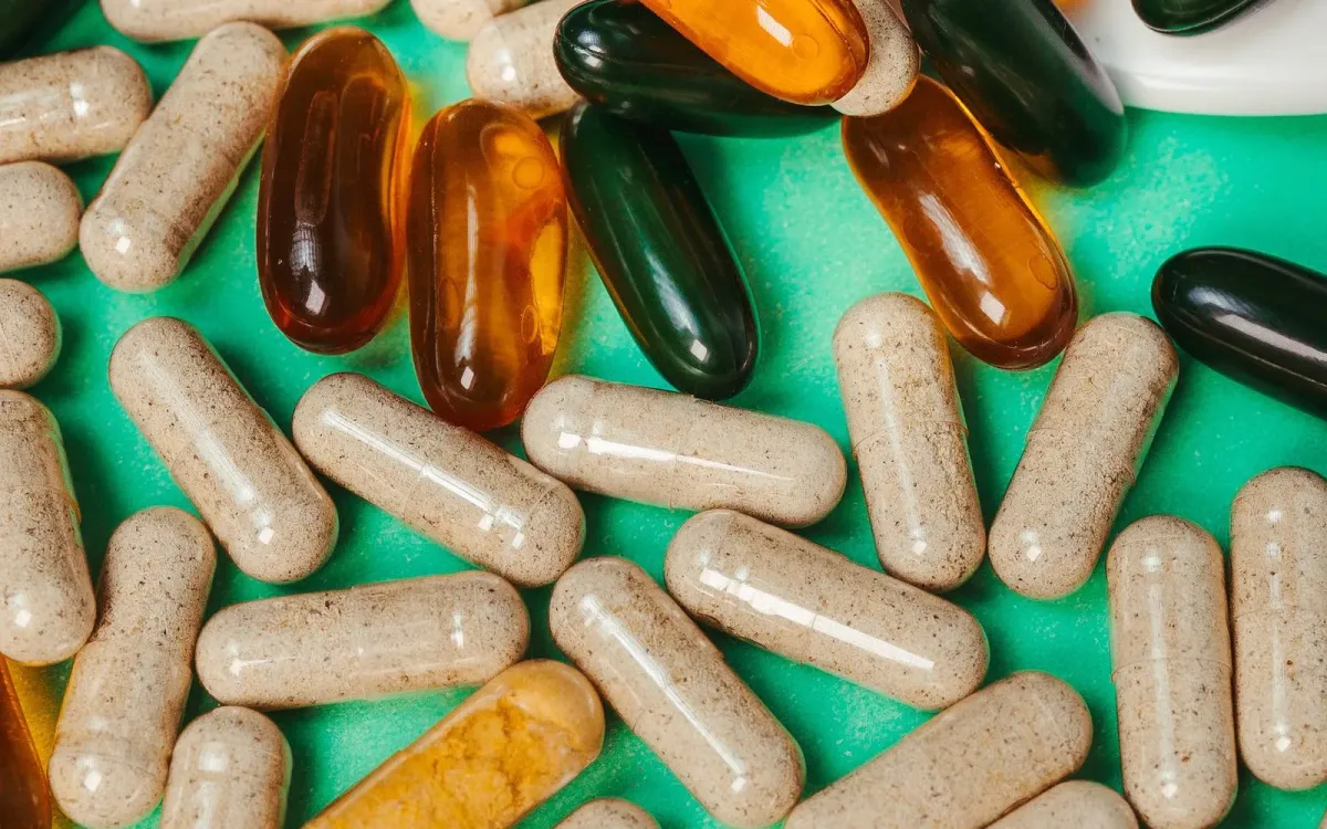 Gélules de compléments alimentaires sur fond vert