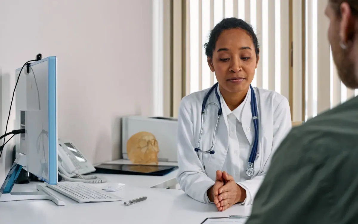 Médecin en consultation face à sa patiente
