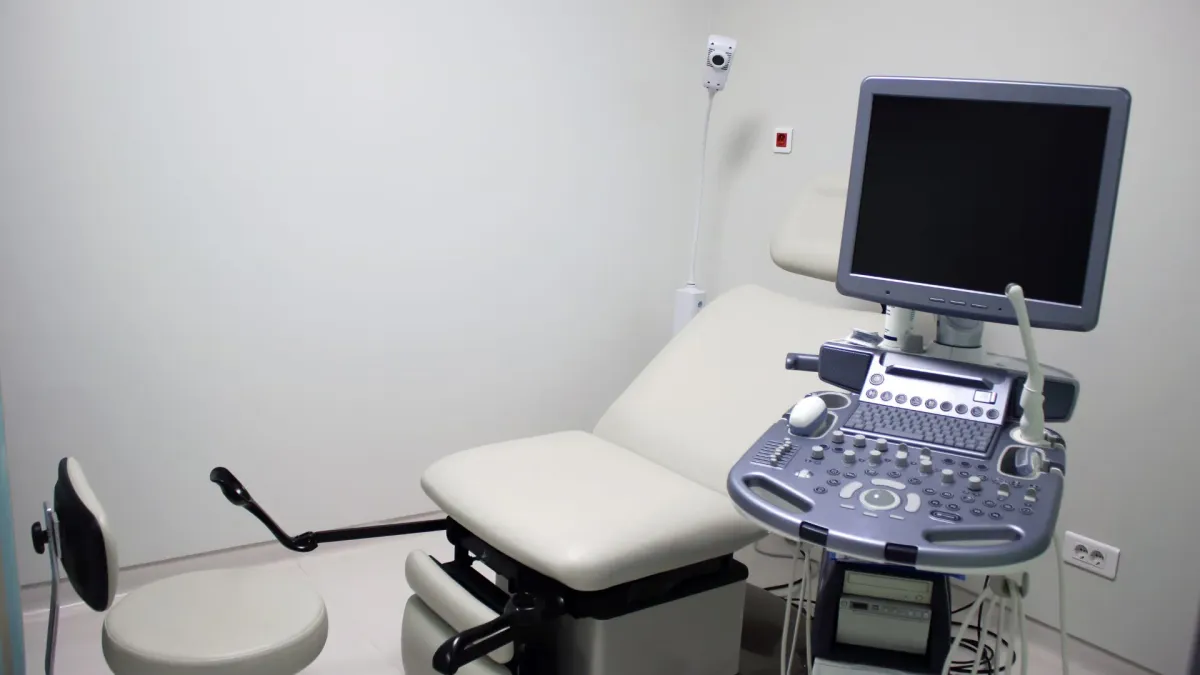 Salle d'examen gynécologique avec un appareil d'échographie et un fauteuil