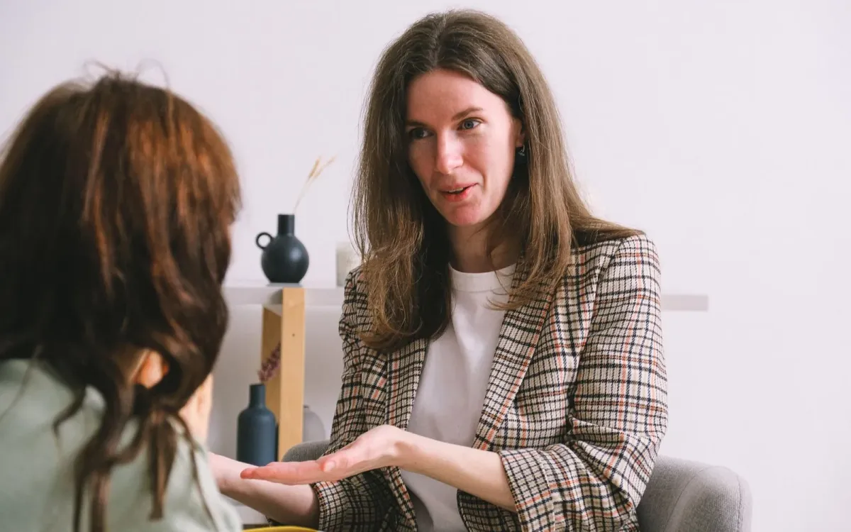 Une naturopathe explique quelque chose à une femme assise en face d'elle, pendant une consultation