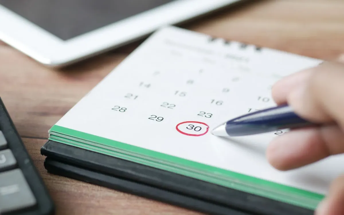 Main qui entoure une date sur un calendrier