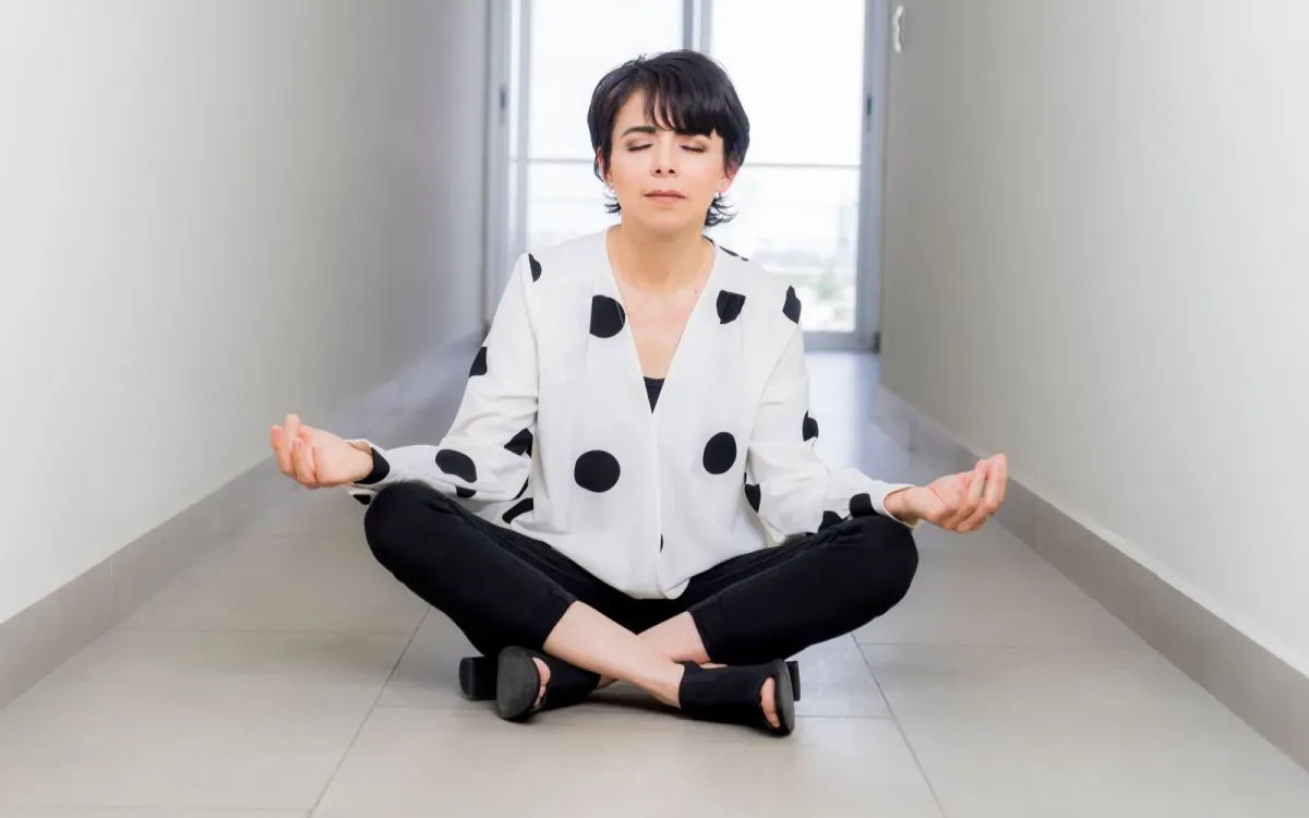 Femme assise en tailleur, les yeux fermés