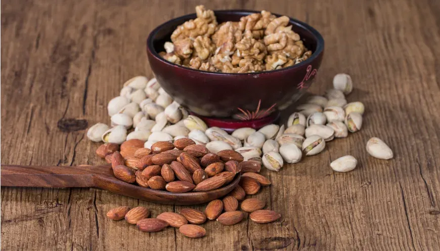 Bols d'amandes, de noix et de graines posés sur du bois