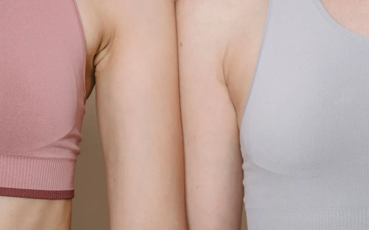 Buste d'une femme en débardeur clair, bras le long du corps