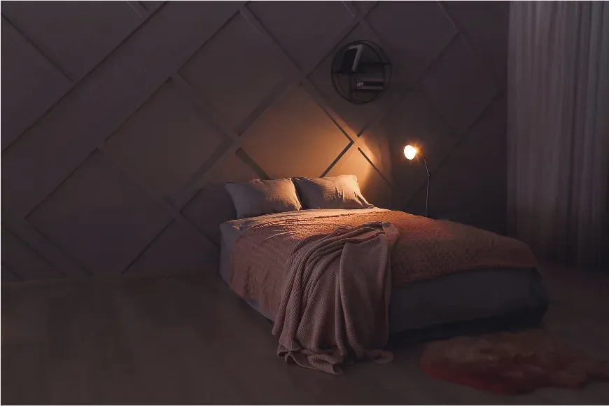 Chambre la nuit, éclairée par une seule lampe à lumière chaude