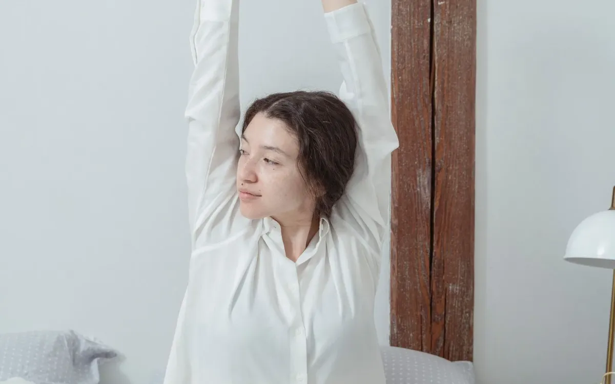 Femme qui s'étire dans son lit au réveil
