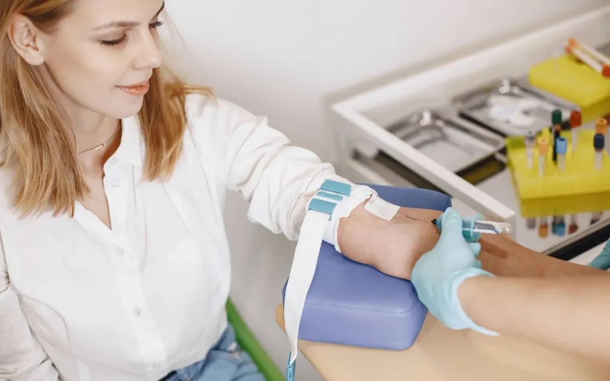 Infirmière réalisant une prise de sang au pli du coude