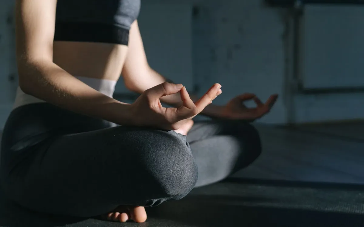 Femme assise sur un tapis, en pause, à l'intérieur