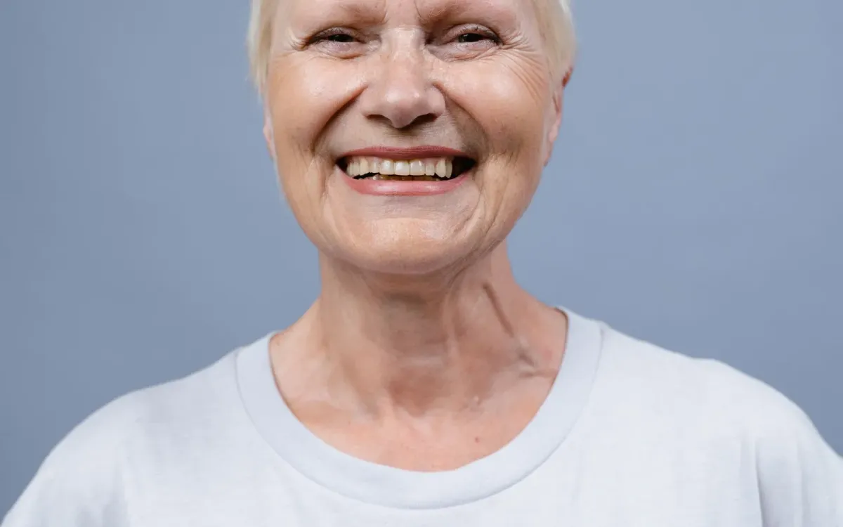 Femme souriante sur fond neutre, sereine après un bilan Femme souriante sur fond neutre, sereine après un bilan