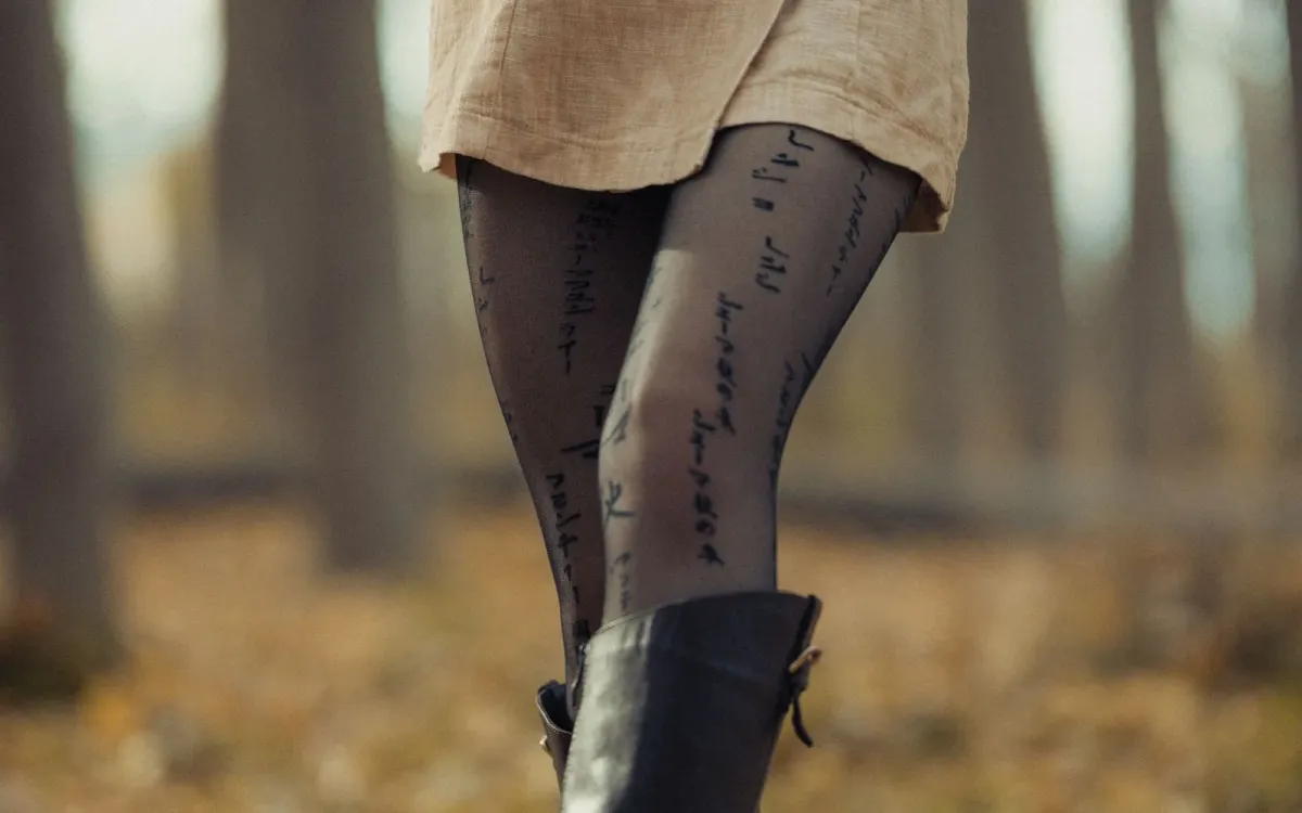 Femme en tenue d'automne parmi les feuilles mortes