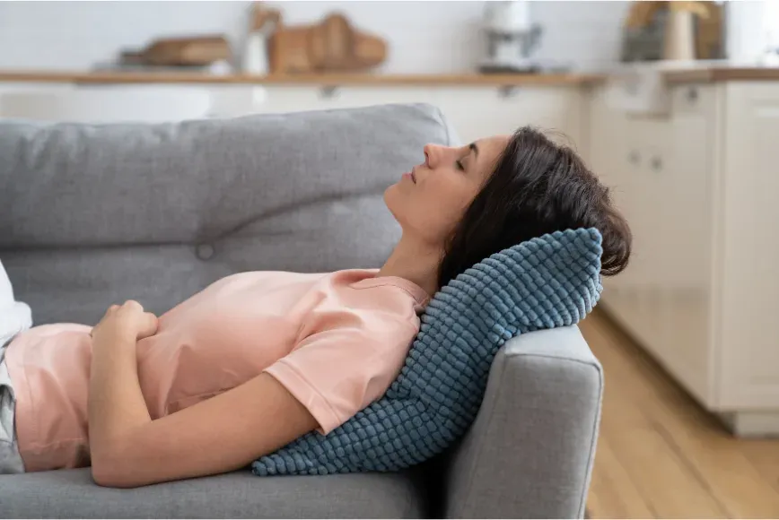 Femme assoupie sur un canapé en pleine journée
