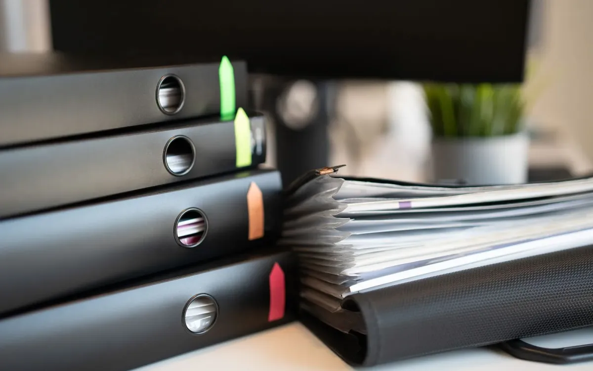Classeurs et dossiers empilés sur un bureau