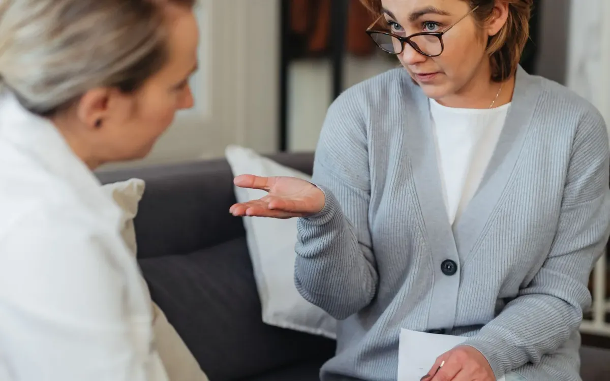 Femme expliquant un compte rendu à une autre femme, assises côte à côte