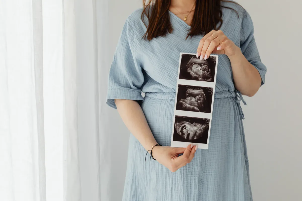 Femme enceinte tenant une bande d'échographie devant elle