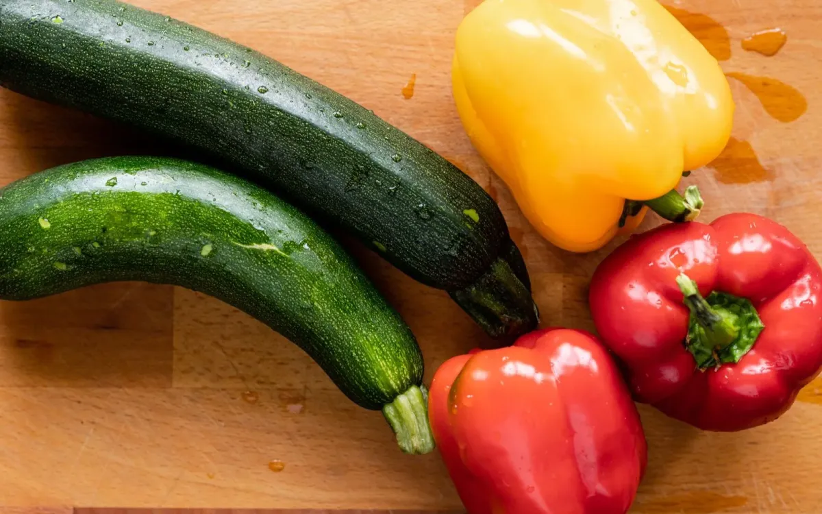 Poivrons et courgettes frais posés sur une planche