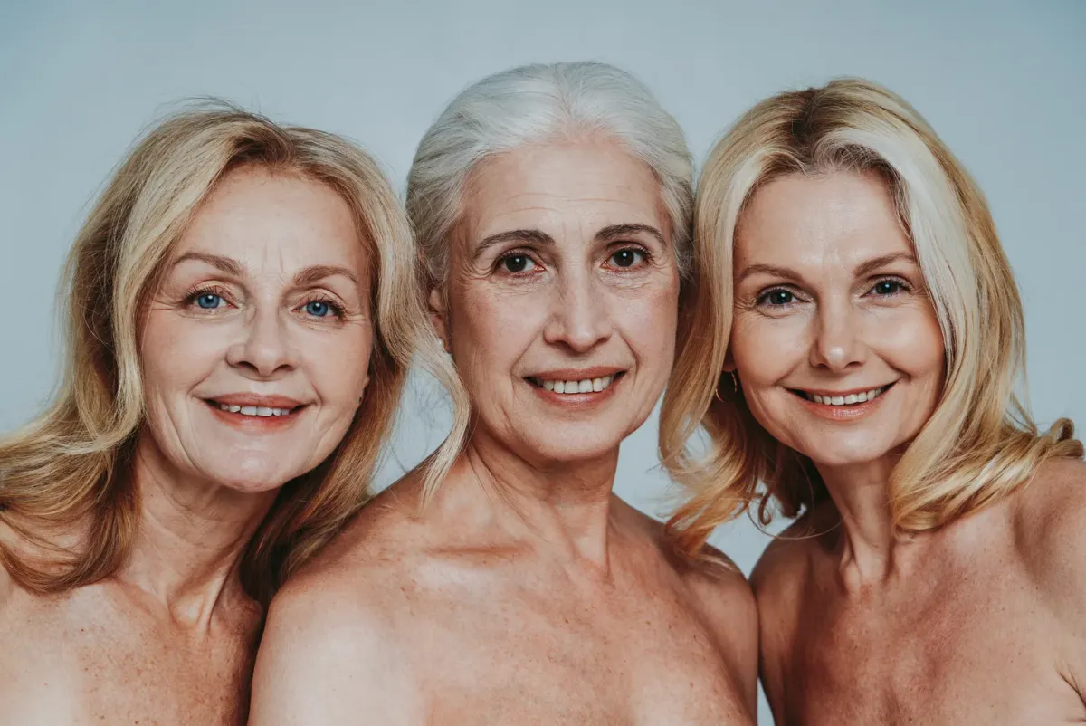 Trois femmes aux cheveux gris, souriantes, côte à côte