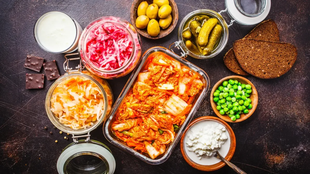 Assortiment d'aliments fermentés : kimchi, choucroute, cornichons, laitages