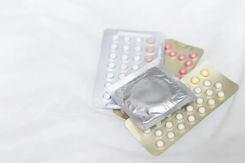 Plaquettes de pilule contraceptive posées sur un drap clair