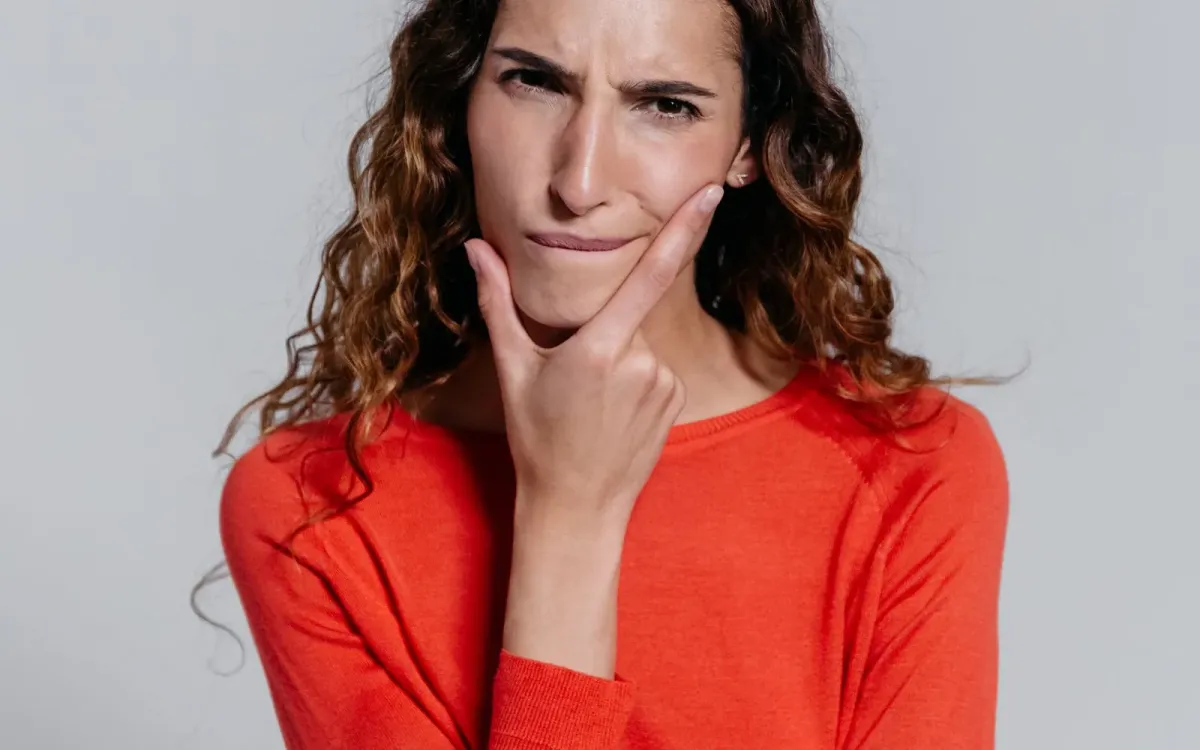 Femme dubitative, la main sur le menton