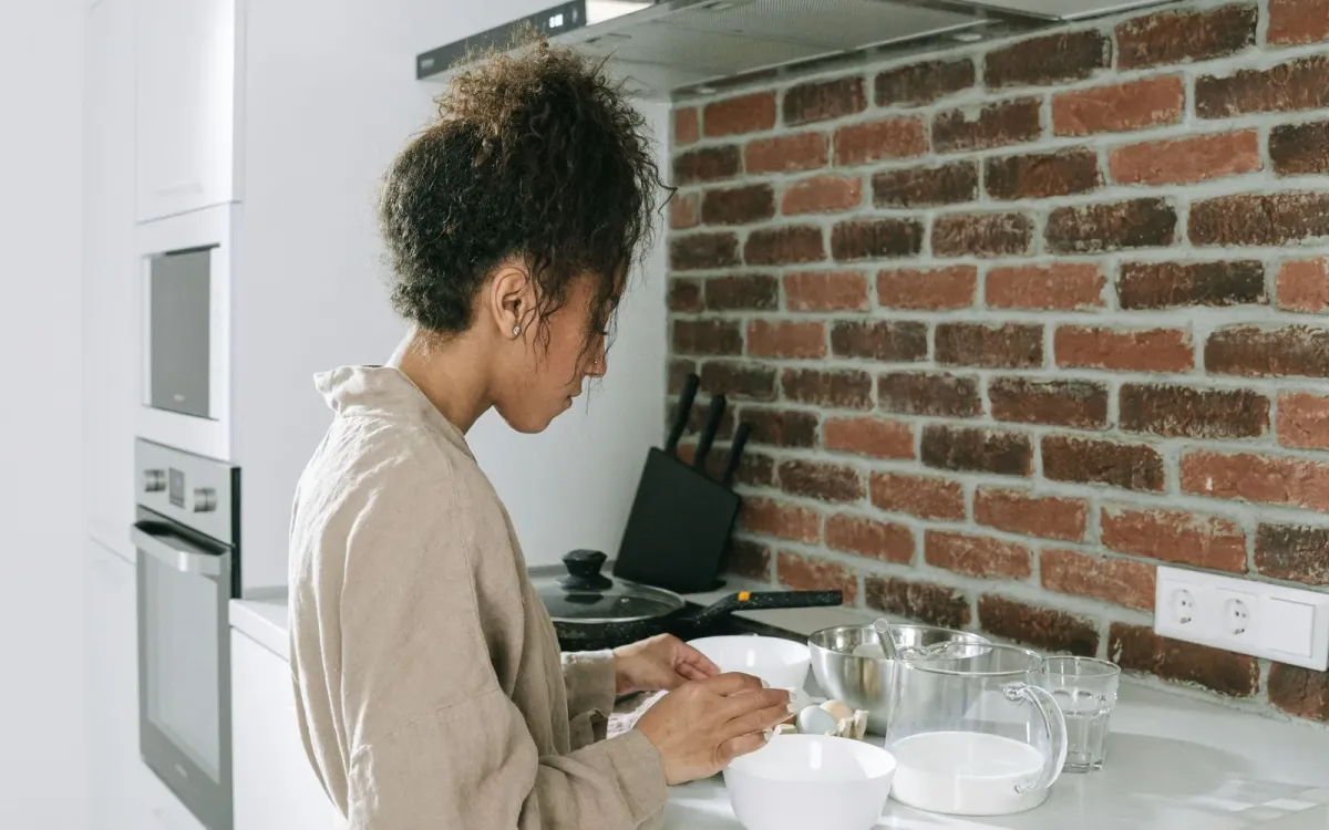Femme qui prépare son repas dans sa cuisine