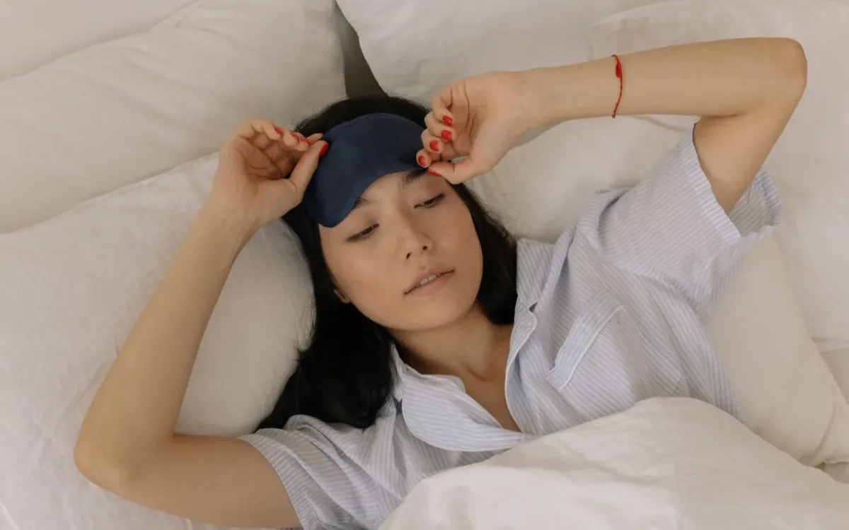 Femme qui relève son masque de sommeil au réveil