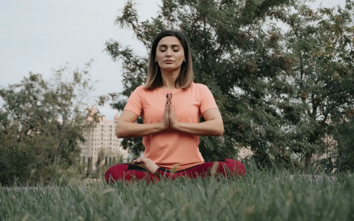 Femme qui pratique le yoga dans un parc
