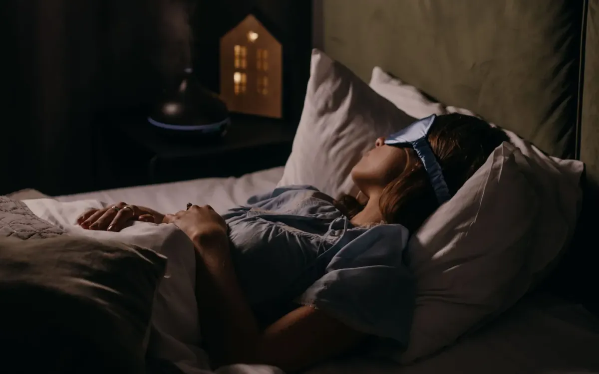 Femme allongée dans son lit, réveillée dans la pénombre