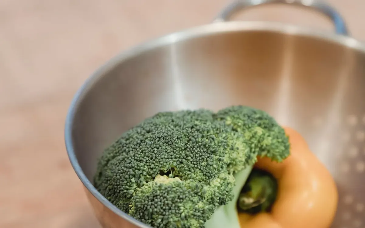 Brocoli et poivron rincés dans une passoire de cuisine