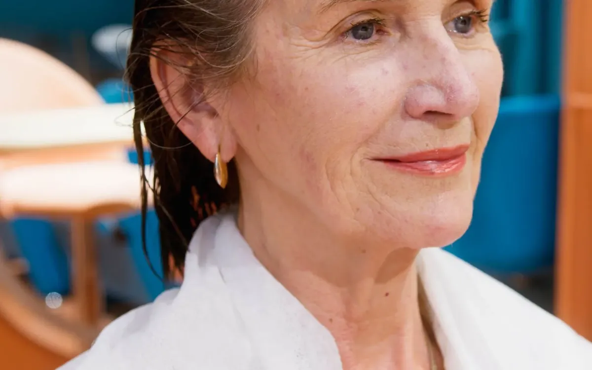 Femme posant doucement la main sur son cou, à hauteur de la thyroïde