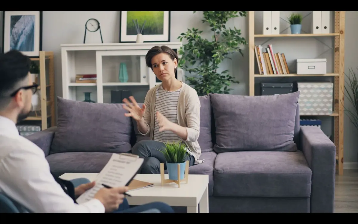Femme en consultation face à une thérapeute dans un bureau lumineux