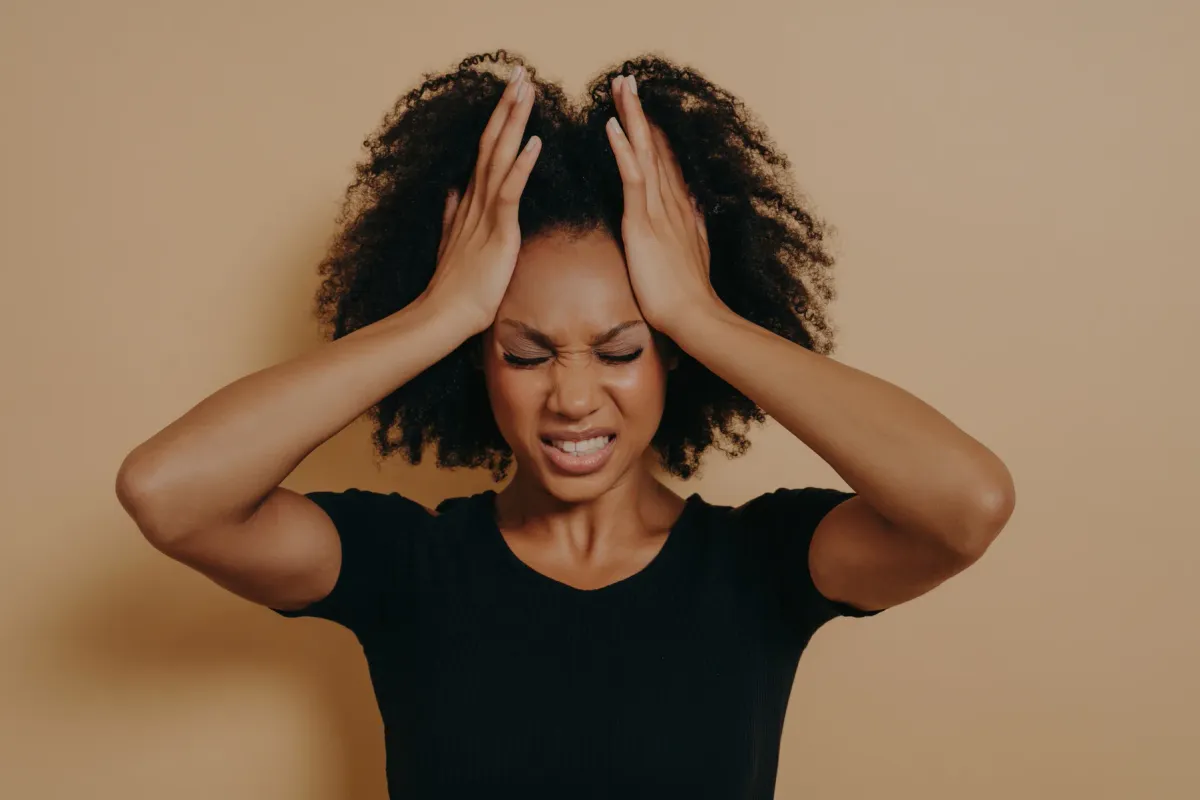 Femme assise, une main sur le ventre, l'air incommodée