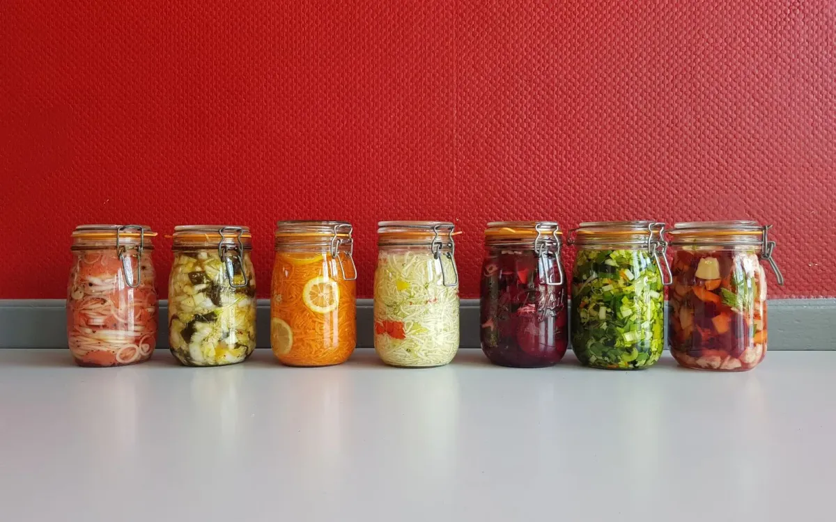 Des bocaux de légumes fermentés alignés, alliés du microbiote