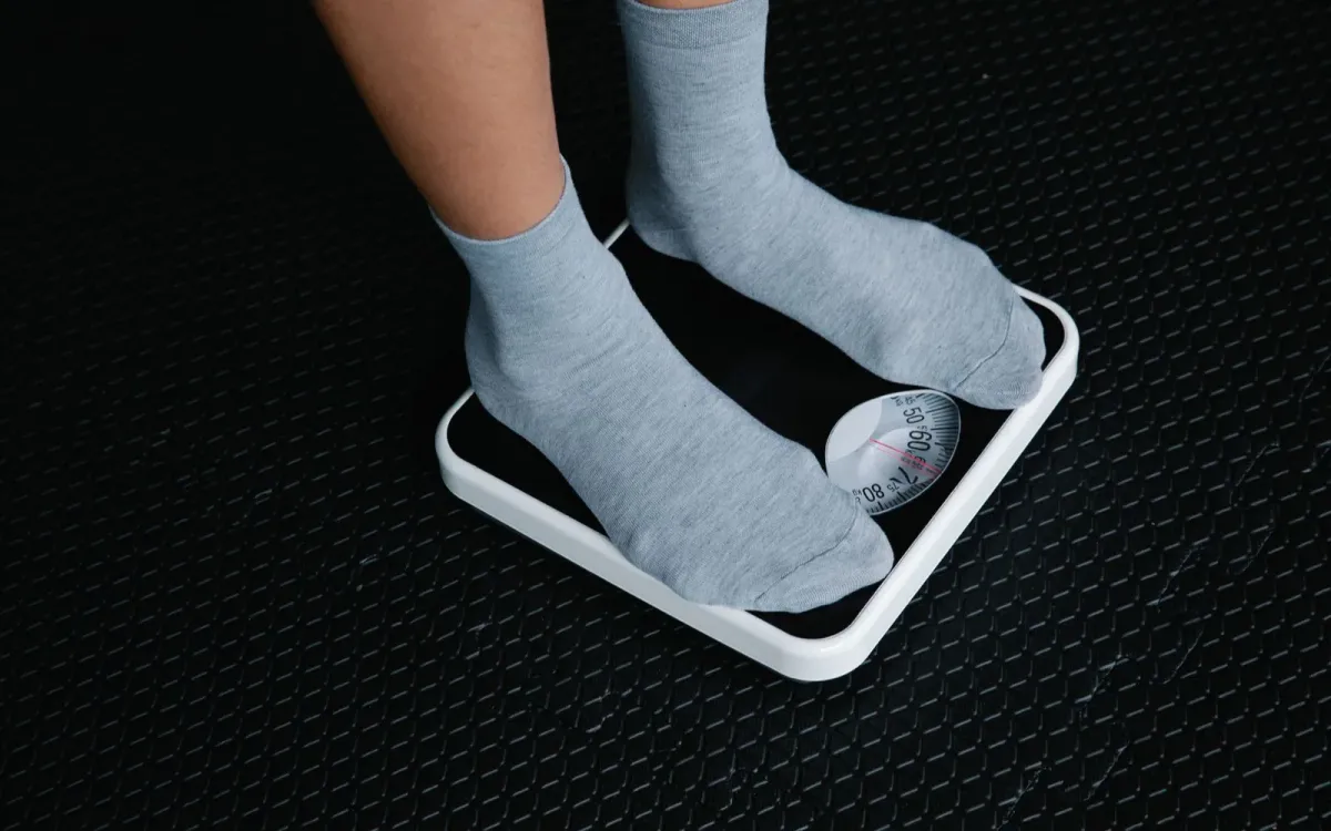 Des pieds en chaussettes posés sur une balance