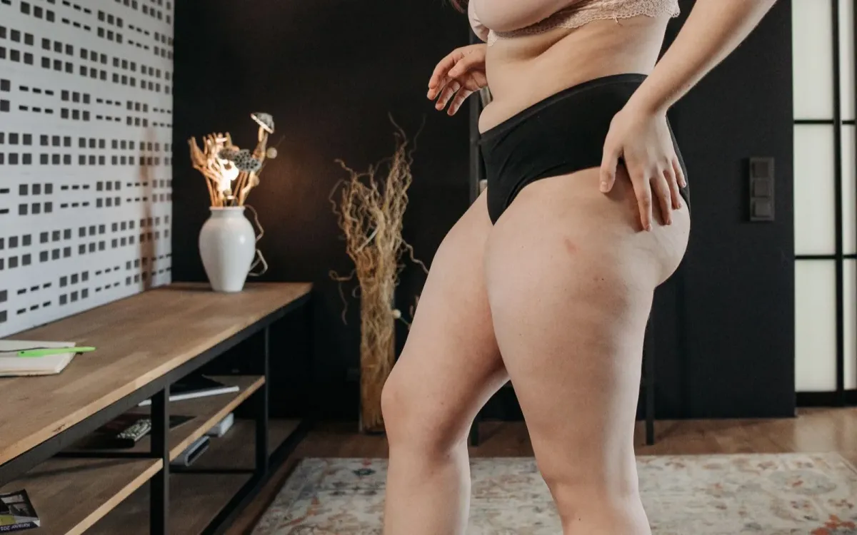 Une femme monte sur sa balance chez elle