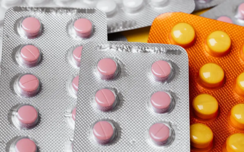 Gros plan sur des plaquettes de comprimés roses, la pilule contraceptive au quotidien